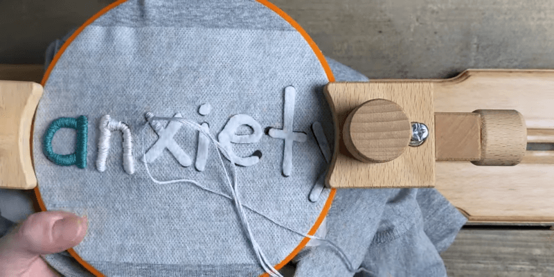 embroidered the word anxiety on a blue sweatshirt