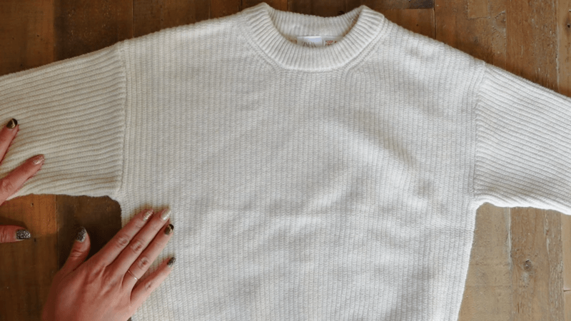 A white sweater spread evenly on the floor