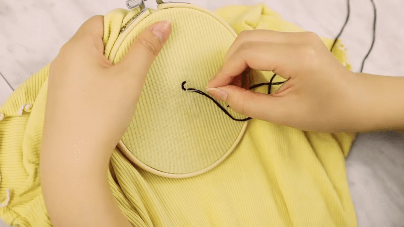 A hoop holds a white shirt ready for embroidery