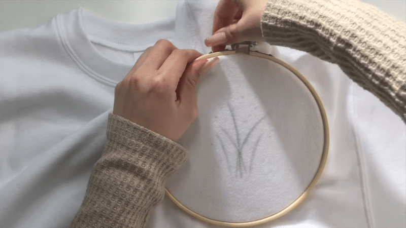 a white embroidered sweatshirt with an embroidery hoop