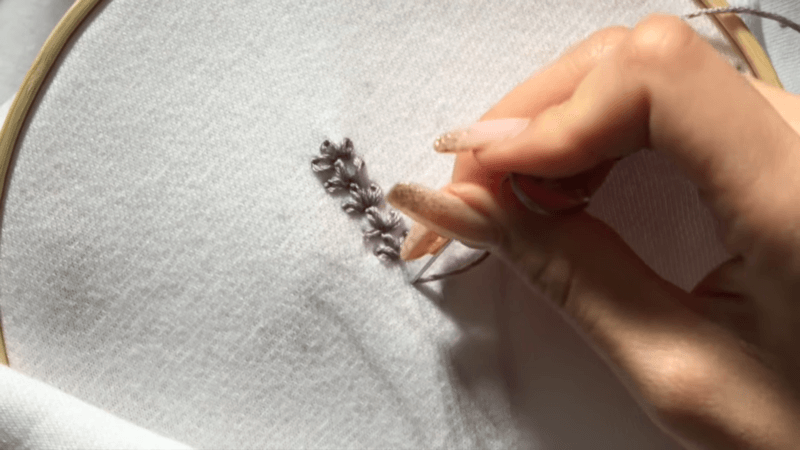 embroidered a plant on white fabric