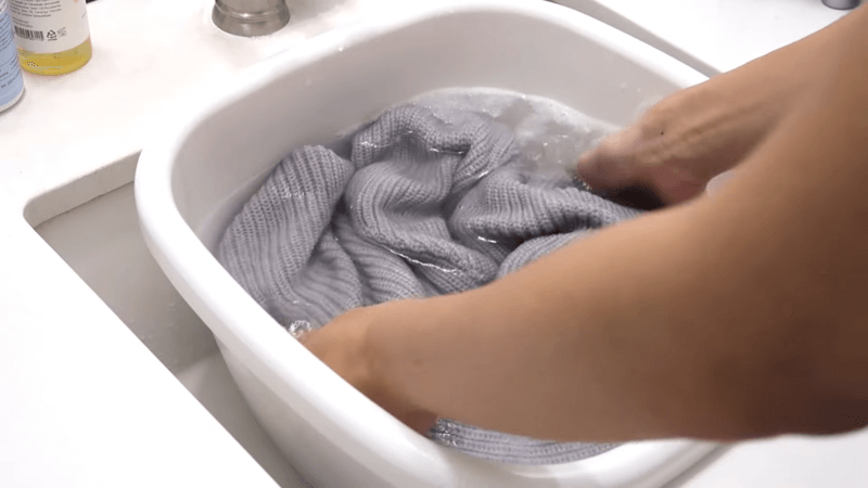 clothing is washed by hand in basins