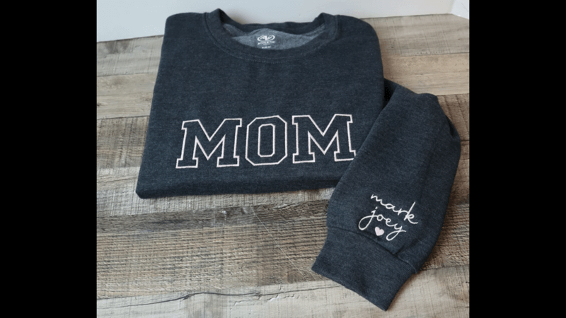 black embroidered sweatshirt with mom text on the floor