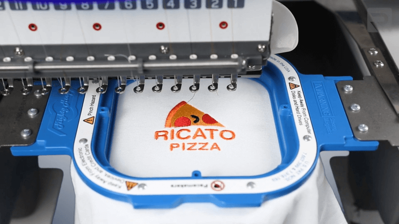 white sweatshirt with ricato pizza logo on embroidery machine